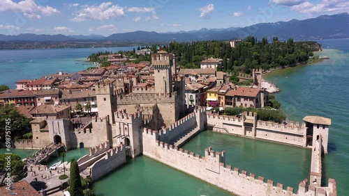 Sirmione drone view circular flight. The historical part of the city of Sirmione on Lake Garda in Italy, slow motion shot by drone. Scaliger Castle of the city of Sirmione 4K video on drone. photo