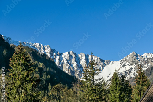 Panoramic view of Karawanks mountain range on sunny day in Carinthia, Austria. Looking at snow capped summit of Vertatscha and Hochstuhl. Remote high alpine landscape in Bodental, Austrian Alps