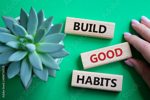 Build good habits symbol. Wooden blocks with words Build good habits. Beautiful green background with succulent plant. Businessman hand. Business and Build good habits concept. Copy space. photo