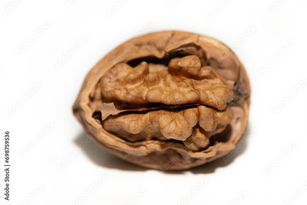 Close-up of a single walnut against a white background. The nut is partially open. You can see the contents. Close-up of a single walnut against a white background. The nut is partially open. You can see the contents.