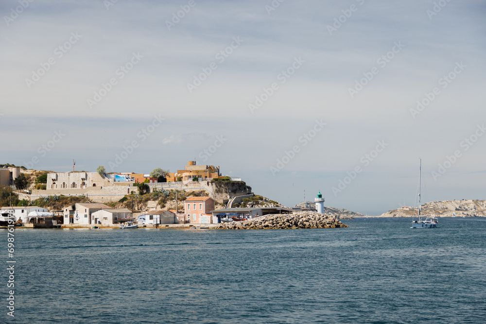 Exiting the port of Marseille into the sea, view of the green lighthouse.