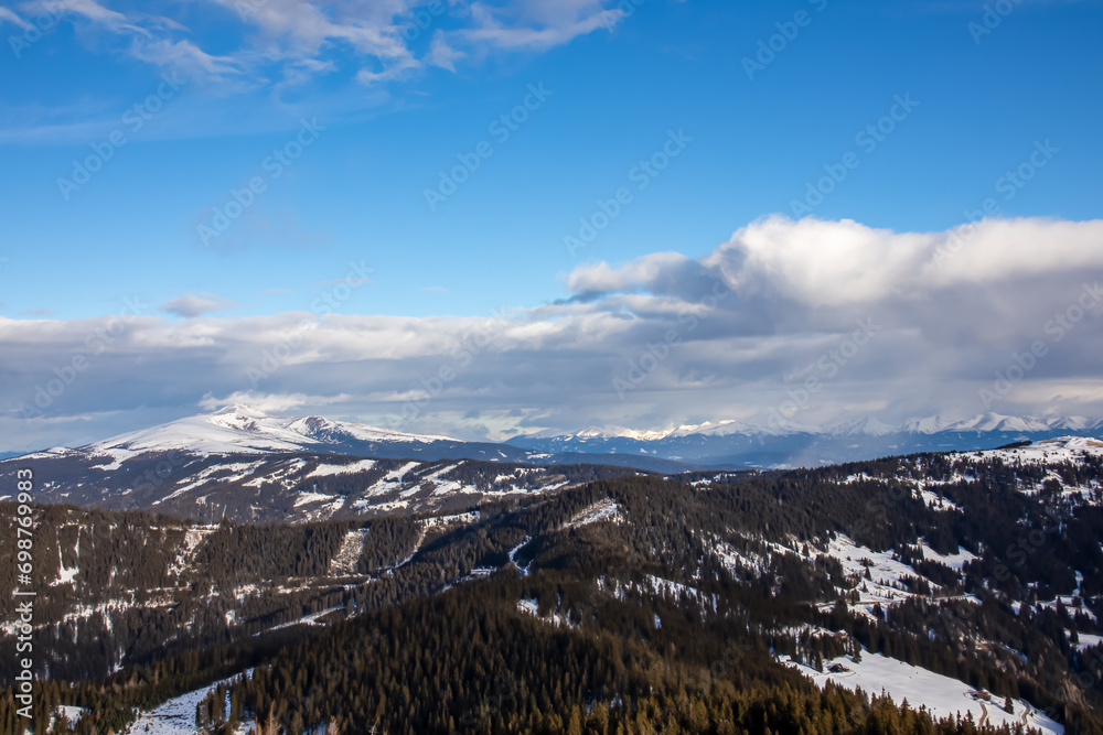 Panoramic view of forest and snow capped mountain peak Zirbitzkogel seen from Forstalpe, Saualpe, Carinthia, Austria, Europe. Alpine hiking trail in Central Alps in winter on sunny day