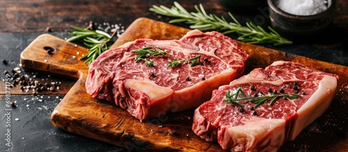 Two wagyu porterhouse steaks displayed on a wooden board. photo