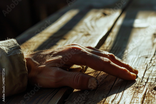 A detailed shot of a person's hand resting on a wooden table. Suitable for various purposes