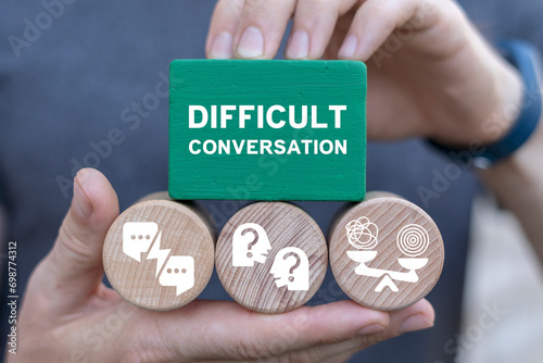 Man holding multi-colored blocks sees inscription: DIFFICULT CONVERSATION. Difficult conversation concept. Serious talk in sensible subjects at work or relationship, discuss personal issues conflict. photo