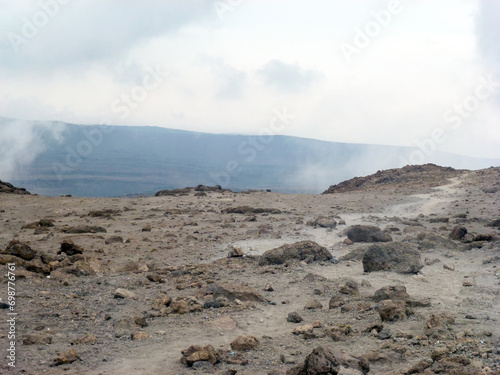 A large desert valley in the mountains with piles of stones. Desert landscape photo