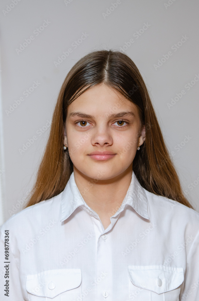 Portrait of a fourteen-year-old girl in a white shirt on a gray background Portrait of a fourteen-year-old girl in a white shirt on a gray background