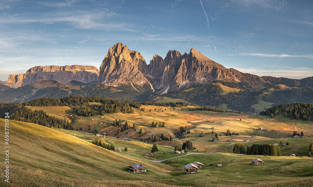 Stunning sunset at Langkofel with colorful sky at Italian Dolomites. Impressive Sassolungo mountain with Alpine lodges.