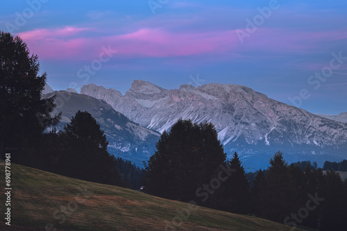 Obraz na płótnie Stunning sunset at Langkofel with colorful sky at Italian Dolomites. Impressive Sassolungo mountain with Alpine lodges.
w salonie