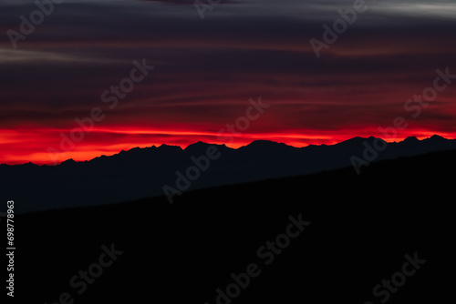 Obraz na płótnie Dark red sky at Italian Dolomites with mountain peaks in distance. Twillight hour at Italian Alps. w salonie