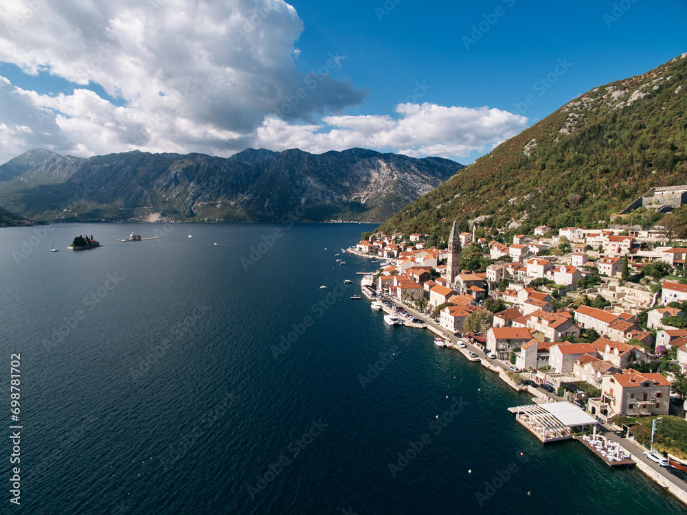 Coast of Perast with ancient houses and church bell tower. Montenegro. Drone
