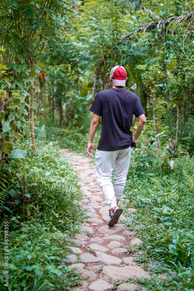 Asian man walking in the tropical forest