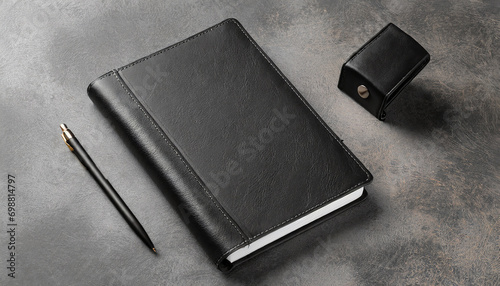 Mockup of a black diary in a leather cover with a pen and a pencil on the table without a logo. A5 notebook