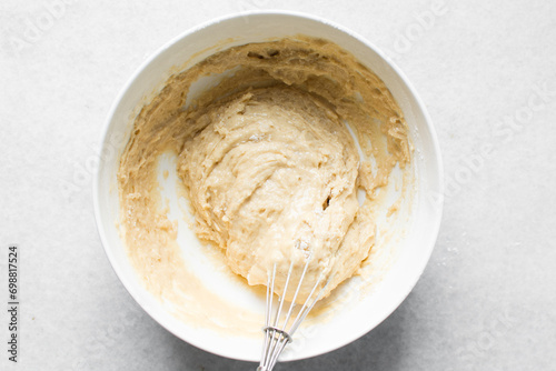 vanilla almond muffins batter in a white mixing bowl, almond muffins batter in a white ceramic bowl, process of making almond muffins photo