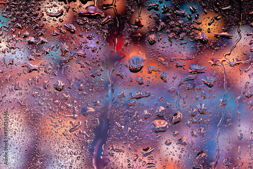 Abstract background. Water drops on glass. Drops of rain on the window. Multi-colored spots. Texture of drops. Selective focus
