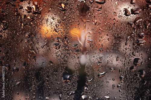 Raindrops on the window. Water drops on glass. Abstract background. Storefront lights. Texture of drops