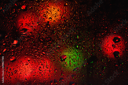 Raindrops on the window. Water drops on glass. Abstract background. Street lights. Texture of drops. Selective focus.