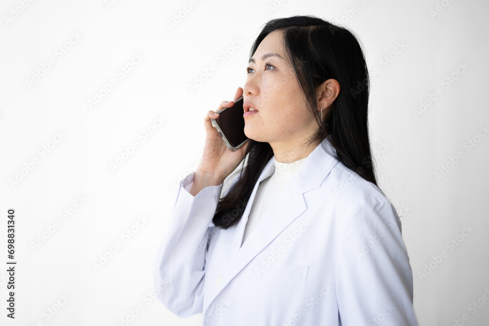 スマホで話す白衣女性 スマホで話す白衣女性