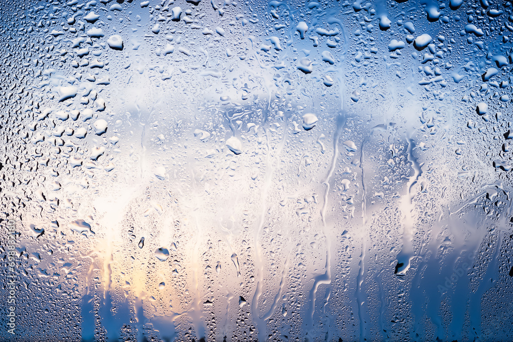 Raindrops on the window. Water drops on glass. Abstract background. Blue sky with clouds. Texture of drops. Selective focus Raindrops on the window. Water drops on glass. Abstract background. Blue sky with clouds. Texture of drops. Selective focus