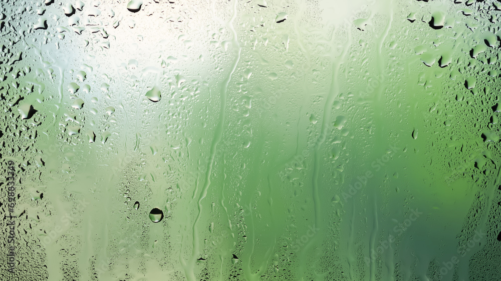 Raindrops on the window. Water drops on glass. Abstract background. Green natural landscape. Texture of drops. Selective focus. Raindrops on the window. Water drops on glass. Abstract background. Green natural landscape. Texture of drops. Selective focus.