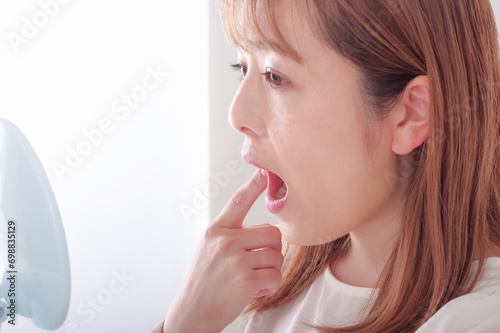 Photography 鏡で口内を確認している若い女性
