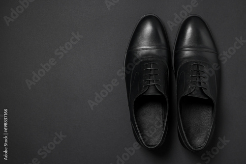 Pair of leather men shoes on black background, top view. Space for text photo