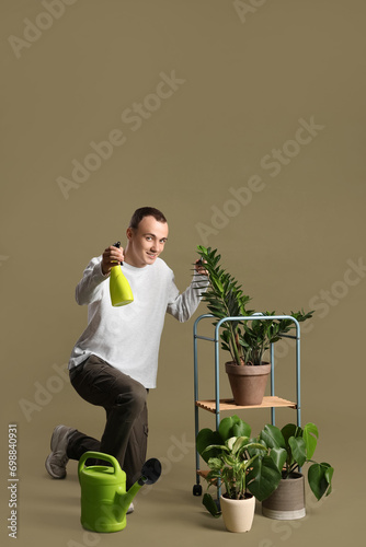 Young man spraying water on...