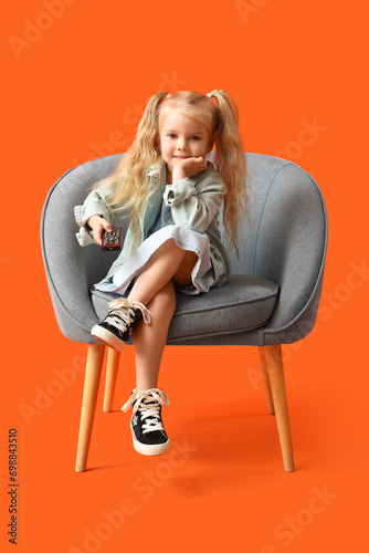 Little girl in armchair wat...