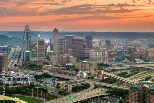 Aerial view of downtown district of Cincinnati city in Ohio, USA at sunset. Brightly illuminated high skyscraper buildings in modern American midtown