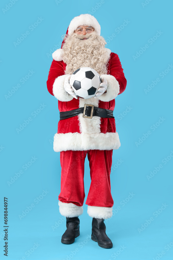 Santa Claus with soccer ball on blue background Santa Claus with soccer ball on blue background