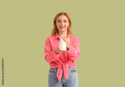 Mature woman with bottle of...