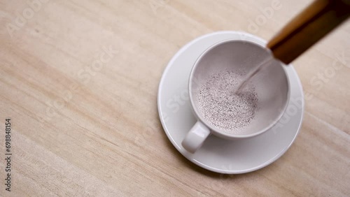 Package of coffee 3 in 1 poured into a disposable Cup. Instant coffee falling into mug.
