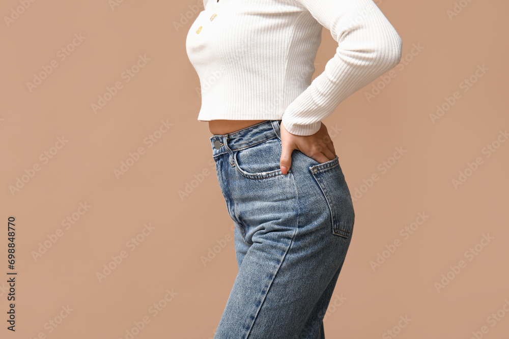 Beautiful young Asian woman in stylish jeans on brown background, closeup - obrazy, fototapety, plakaty 