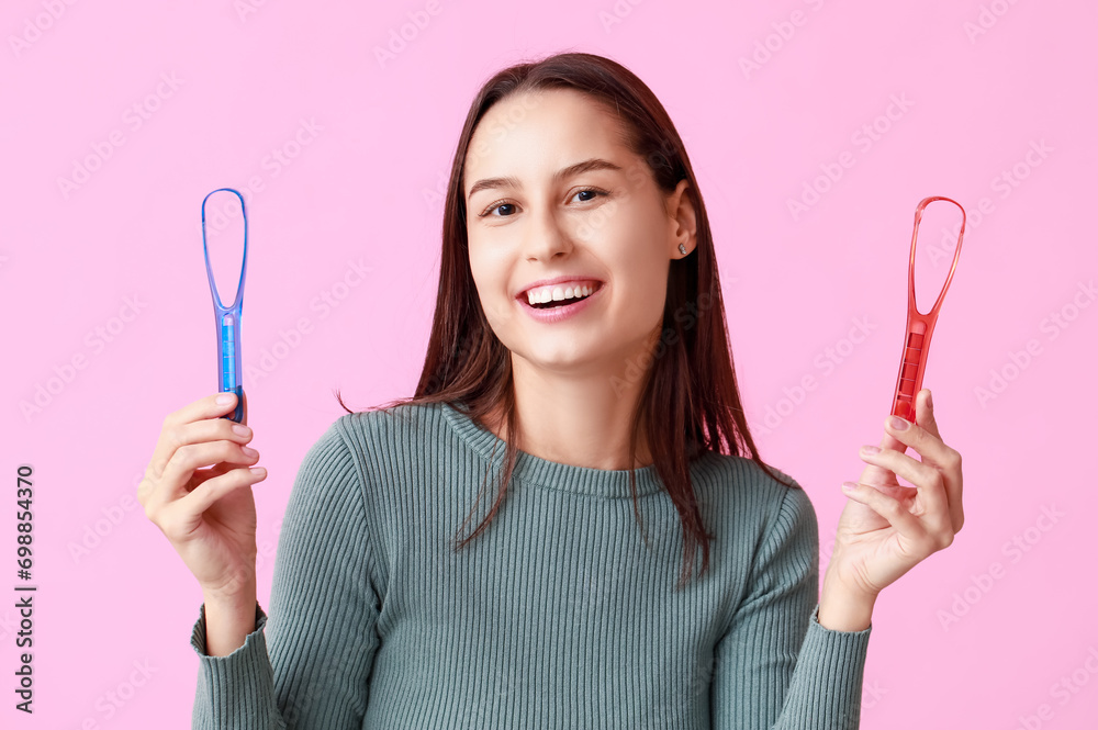 Beautiful young woman with tongue scrapers on pink background Beautiful young woman with tongue scrapers on pink background