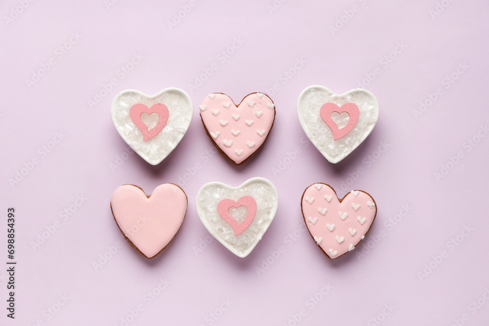 Heart shaped sweet cookies and bowls with snow on lilac background. Valentine's day celebration