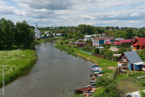 Panoramic view of the Kamenka River and the Church of the Epiphany of Christ (Epiphany Church) in Kozhevennaya Sloboda on a sunny summer day, Suzdal, Vladimir region, Russia