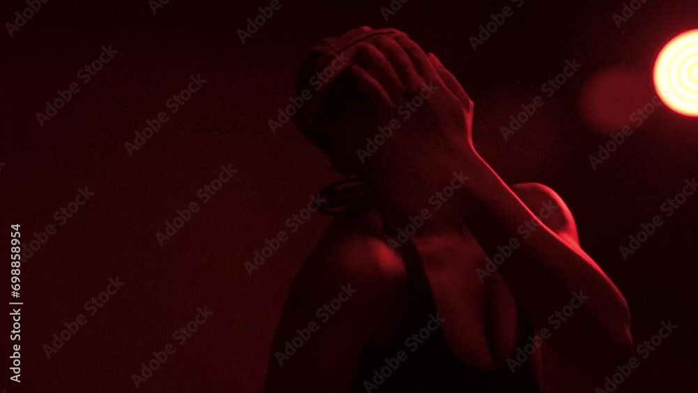 Slow motion of woman solo dancing under red lights Slow motion of woman solo dancing under red lights