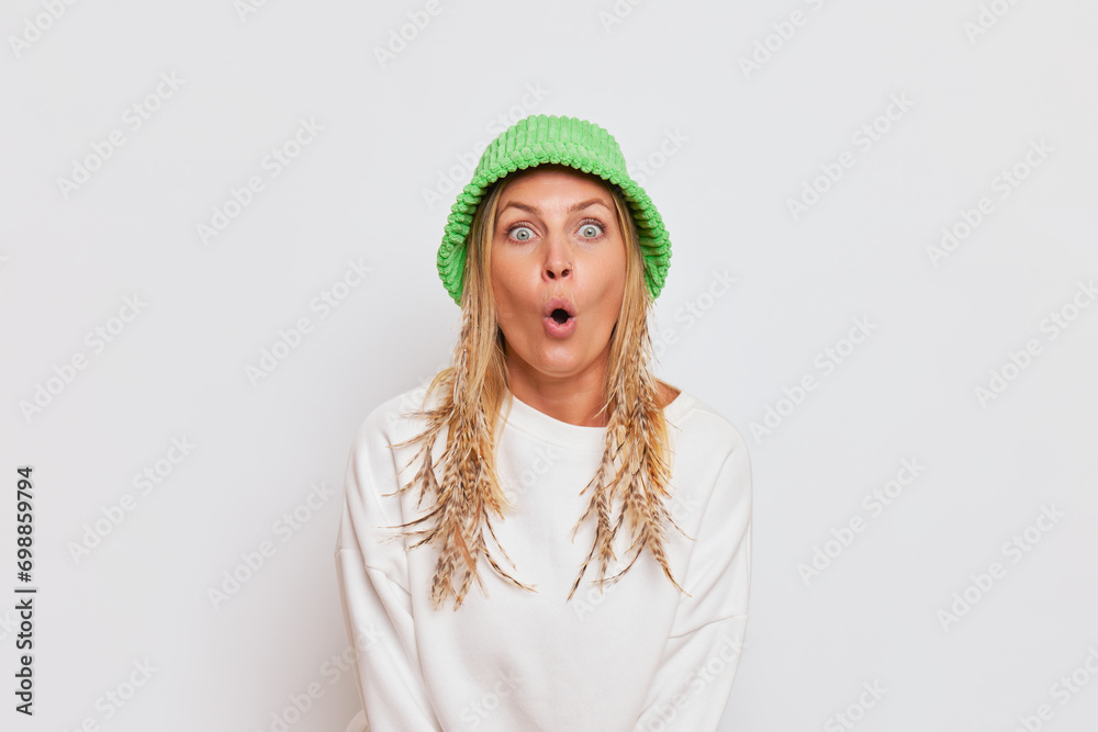 Young woman wearing white clothes and green bucket hat standing isolated over white background, nice day concept, copy space Young woman wearing white clothes and green bucket hat standing isolated over white background, nice day concept, copy space