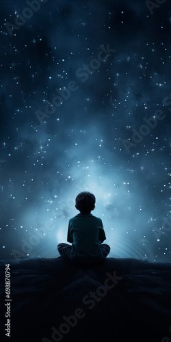 A boy appears from behind and sits looking at the stars © Natali