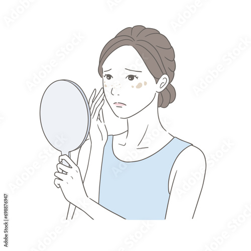 手鏡を見るシミに悩む女性