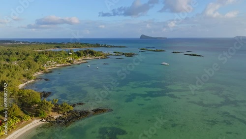 Aerial drone of tropical beach in the Mauritius Island, Indian Ocean.
Calm turquoise ocean, bright blue sky with clouds. Exotic holidays destination landmark. photo