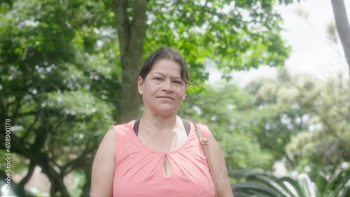 joyful Colombian woman shares a modest yet radiant smile of happiness for the camera, capturing the essence of the Christmas spirit with a touch of bashful charm.
