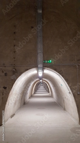 a long underground tunnel with an exit emergency sign on it