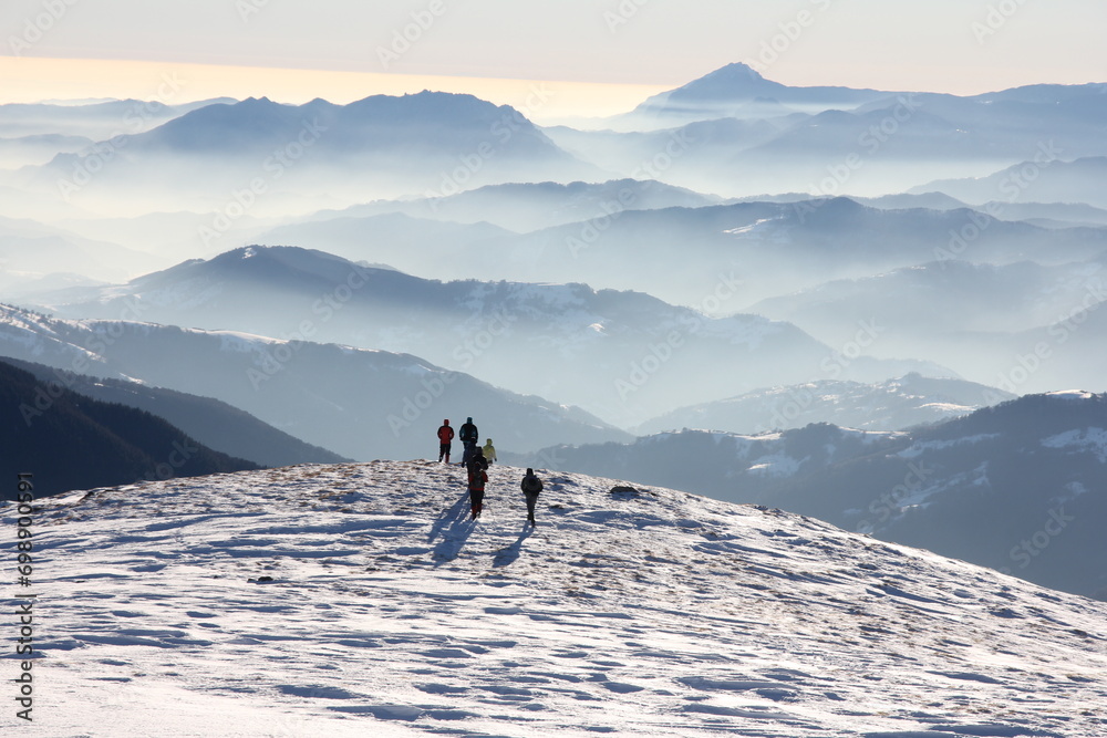 A lively group of people gathered, their faces flushed with excitement, as they stood atop the snow-covered slope.