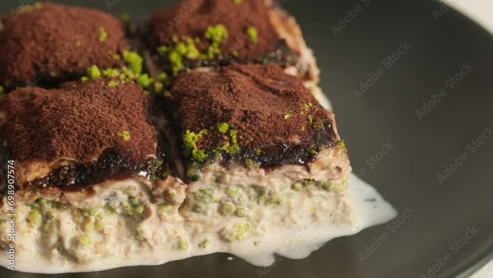 Cold baklava with cocoa on a black plate Cold baklava with cocoa on a black plate