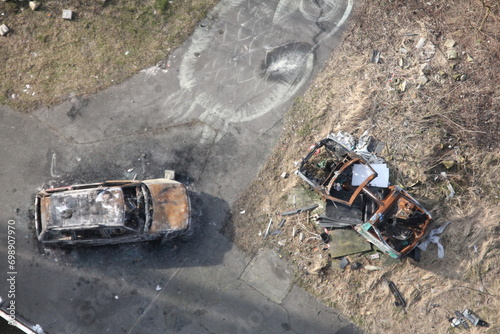 From above, the charred remains of a car spread across the ground, revealing a scene of destruction and loss. photo