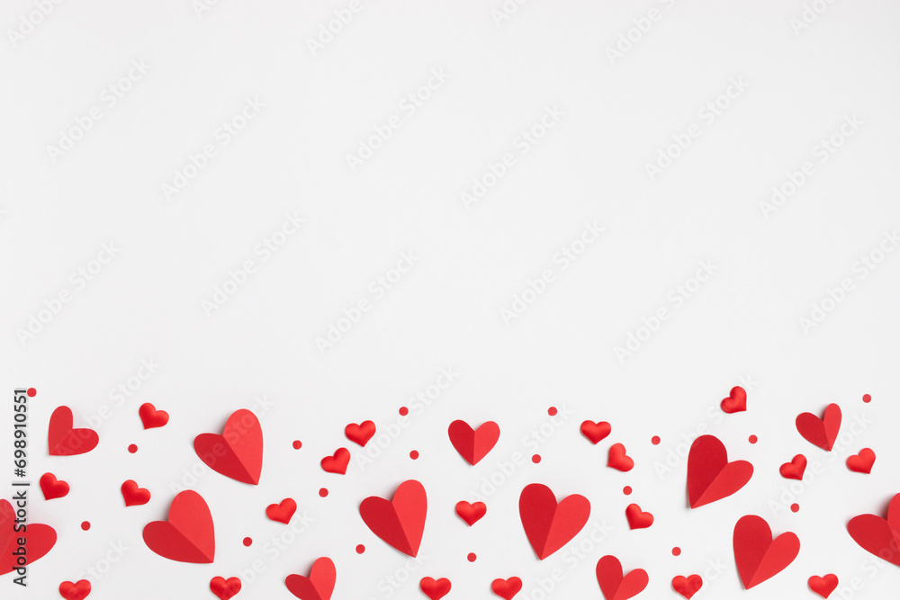 Valentine or Mother day festive greeting card border from various mixed red hearts on white background top view and flat lay.