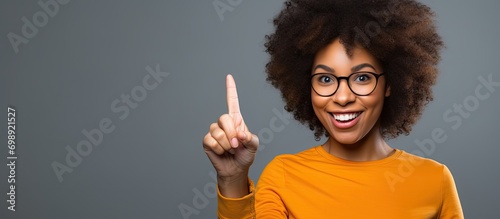 African American woman with an empty frame, pointing finger with a happy face, number one. photo