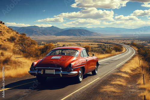 Vintage red sports car rides an empty mountain highway on a sunny day, rear view photo