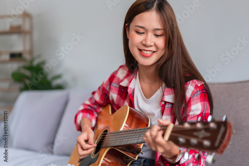 Guitar and singer concept  Young woman learning and practice playing chords with acoustic guitar